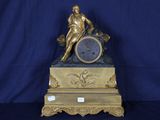 une horloge en or surmontée d'une statue