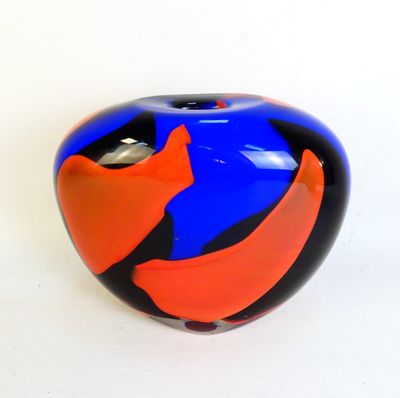 a blue and orange vase sitting on a white surface