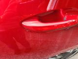 a close up of a red car door handle