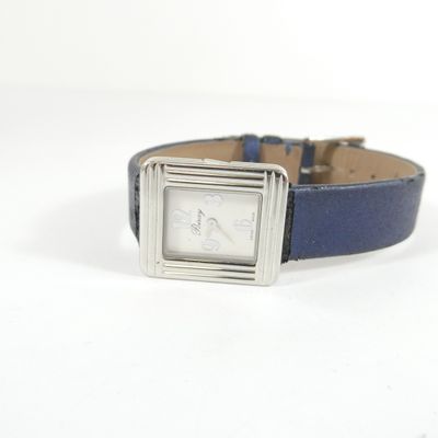 une montre montée sur un bracelet en cuir bleu