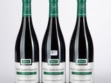 trois bouteilles de vin posées l'une à côté de l'autre sur une table