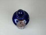 a small blue vase sitting on top of a white table