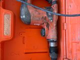 an orange tool box with a drill and a cord in it