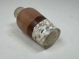 a brown and white bottle sitting on a white surface