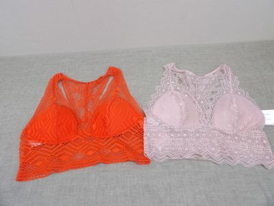two women ' s bras are sitting on a bed next to each other