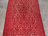 a red and white rug with a pattern on it
