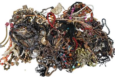 a pile of assorted jewelry on a white surface