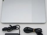 a silver laptop with a charger and a power cord