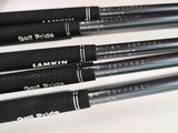 four black pens are lined up on a white surface