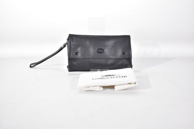 le sac à main en cuir noir est posé sur une surface blanche