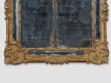 a mirror with a gold frame on a white wall