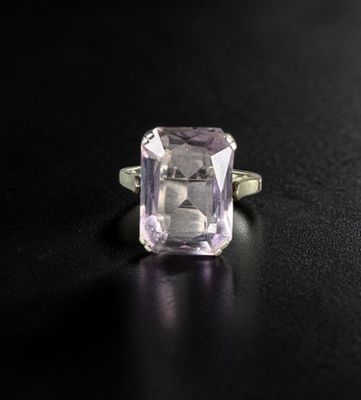 a close up of a ring with an amethorate stone on a black surface