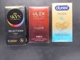 three boxes of condoms sitting on top of a table next to each other
