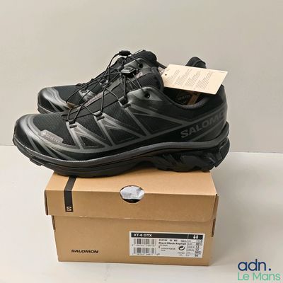 une paire de chaussures noires posée sur une boîte en carton