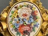 a picture of a gold plated pendant with flowers on it