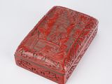 a red box with a design on it sitting on a white surface