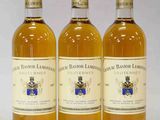 trois bouteilles de vin posées sur une table blanche
