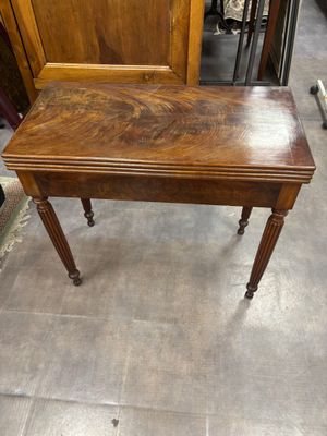une petite table en bois avec un plateau en bois, posée sur un sol carrelé