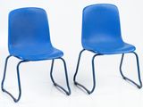 two blue chairs sitting next to each other on a white surface