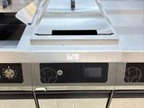 plan de travail en acier inoxydable dans une cuisine professionnelle équipée d'une cuisinière et d'un four