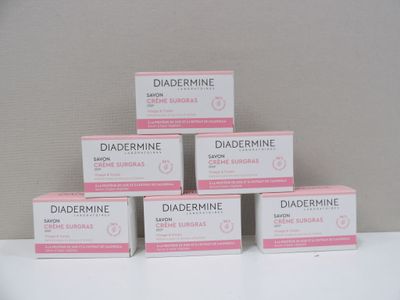 Six boîtes de Diadermine sont posées sur une table devant un mur.