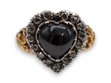 un gros plan d'une bague sertie d'une pierre noire en forme de cœur