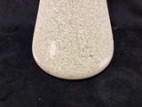 a white vase that is sitting on a black surface