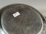 a large silver bowl with a lid on a table
