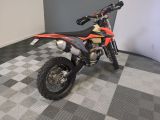 a dirt bike that is parked on a checkered floor