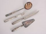 four pieces of silverware including a spoon, knife, and spoon rest