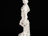 white marble statue of a boy with a basket of flowers on a black background