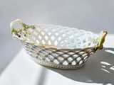 a white basket with a bird on it sitting on a table