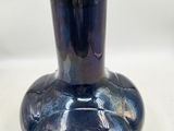 a blue vase that is sitting on a table