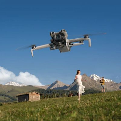 un homme et une femme debout dans un champ, regardant un objet volant