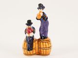 une figurine représentant un homme et une femme assis sur un tonneau