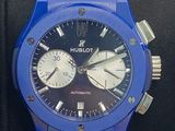 a close up of a blue watch on a black watch band