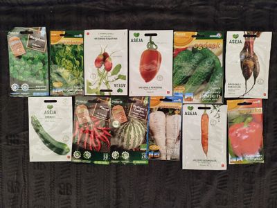 many seed packets of different vegetables on the table