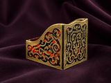 a close up of a gold and red book on a purple cloth