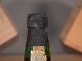 a bottle of wine sitting on a table with a box in the background