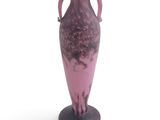 a purple vase that is sitting on a black stand