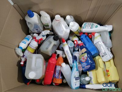 a cardboard box filled with bottles and containers of cleaning products