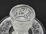 a glass cup and saucer on a plate on a black background