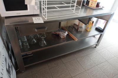 un micro-ondes posé sur une table en acier inoxydable