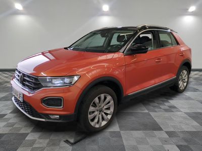 Une Volkswagen T-Cross rouge est garée sur un sol à damier.