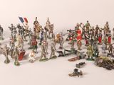 many figurines of different sizes and colors on a white surface