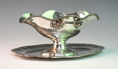 a silver plate with a bowl on it on a table