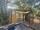 une petite cabane avec une terrasse et un porche couvert