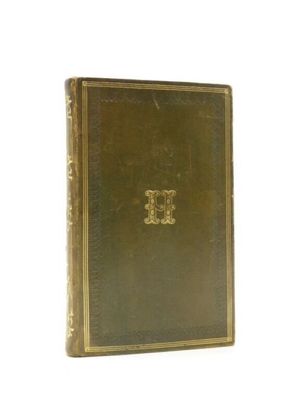 an old book sitting on top of a white table next to a white wall