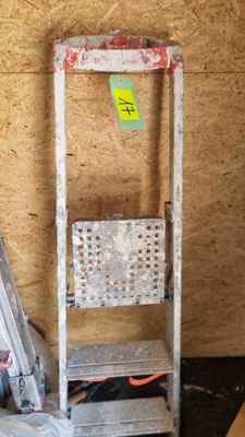 une échelle appuyée contre un mur, sur laquelle se trouve un panier