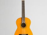 an orange guitar sitting on top of a white surface